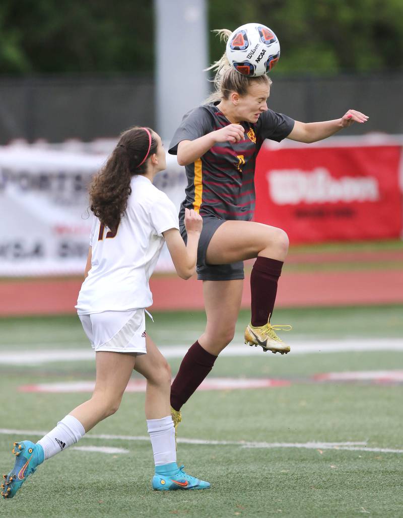 Richmond-Burton's Mckenzie Ragusca heads the ball away from Montini's Naomy Gonzalez Friday, May 27, 2022, during their IHSA Class 1A state semifinal game at North Central College in Naperville.