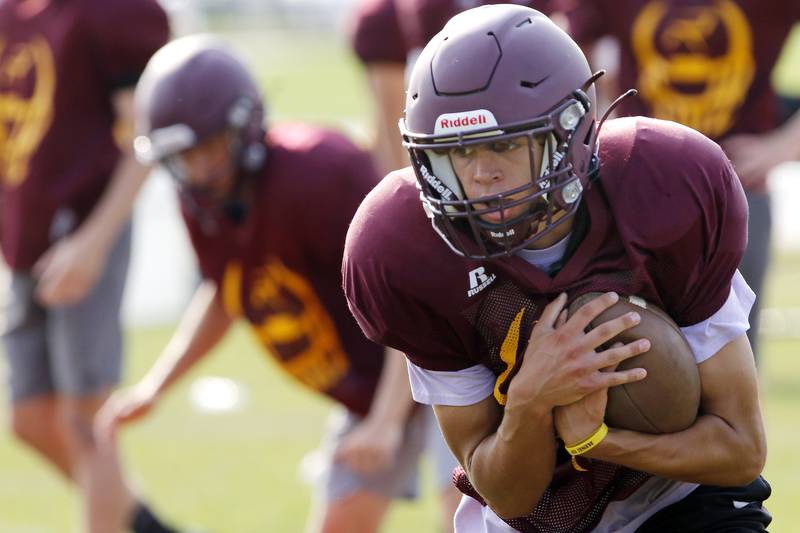 Quarterback Joe Miller recovers the ball during practice with the varsity football team at Richmond-Burton High School on Wednesday, July 14, 2021 in Richmond.