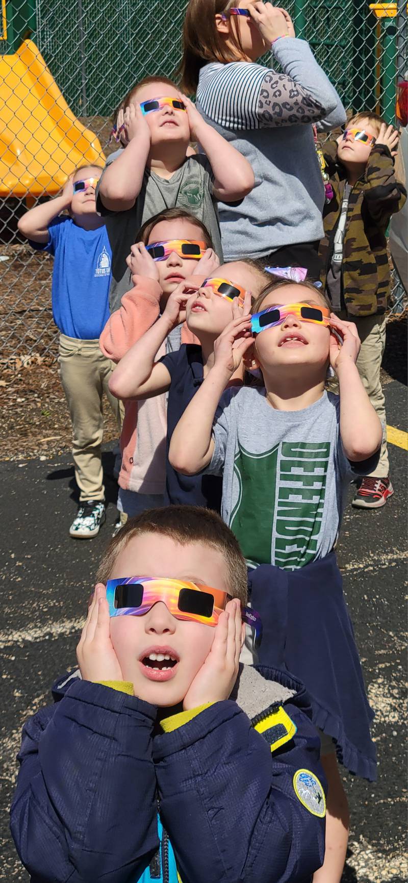 With special glasses clutched tightly to their heads, students from St. Michael the Archangel Catholic School in Streator view Monday's solar eclipse..