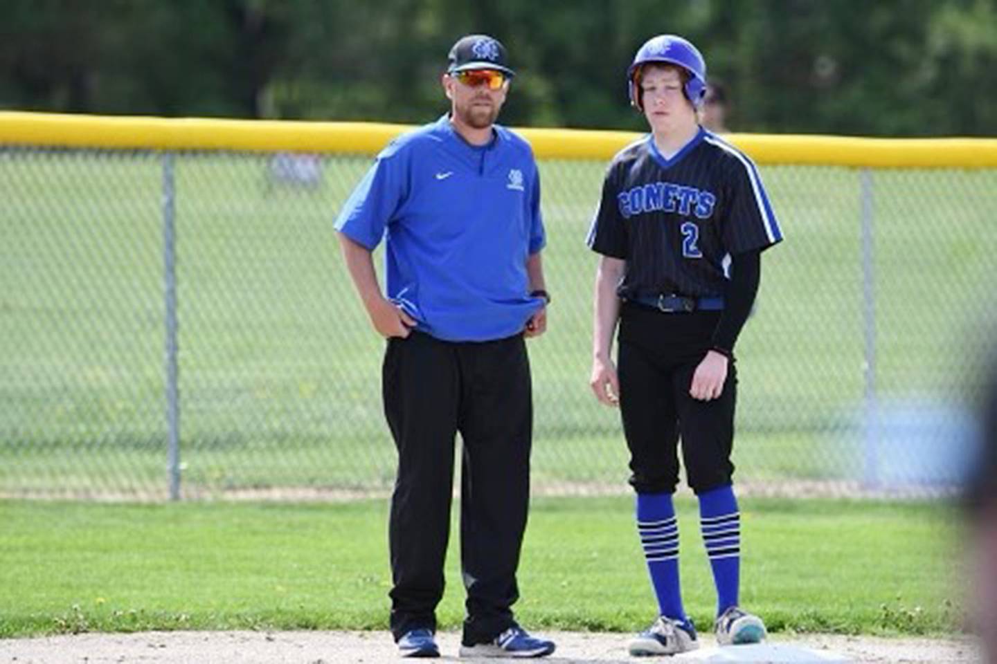 Newman coach Kenny Koerner (left) talks with Daniel Kelly at third base during a game this season.