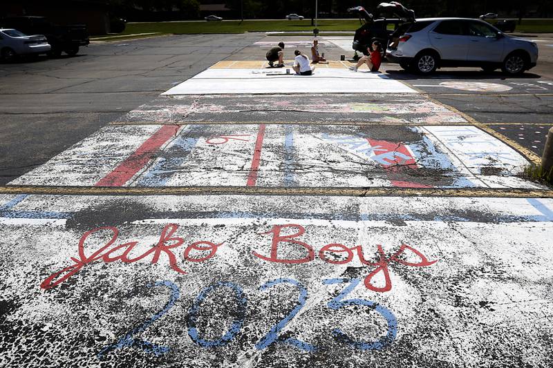 Painted parking spots from 2023 fade students and a graduate from Marian Central Catholic High School work on painting parking spots for this year’s juniors and seniors on Tuesday, Aug. 13, 2024, before the students to return to school on Thursday, Aug. 15. This is the third year that the school's students have been able to bid at an auction to paint their parking spots at eh Woodstock school.