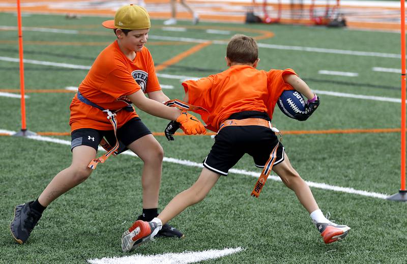 Vinny Vlahos grabs the flag as Greyson Jett tries to get away during the Chicago Bears Mini Monsters Flag Football Camp on Wednesday, July 16, 2025. at McCracken Field in McHenry.