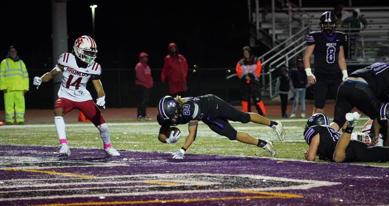 Downers Grove North's Noah Battle (20) dives into the end zone for a touchdown against Kenwood during a class 7A playoff football game at Downers Grove North on Friday, Oct. 27, 2023.