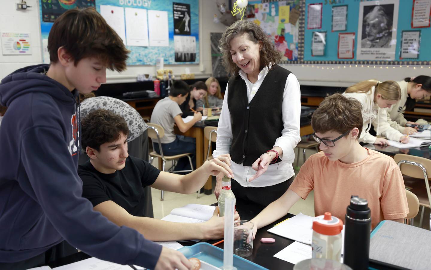 Science teacher Amy Schwartz helps her eighth-grade students with an experiment at Edison Middle School in Wheaton.