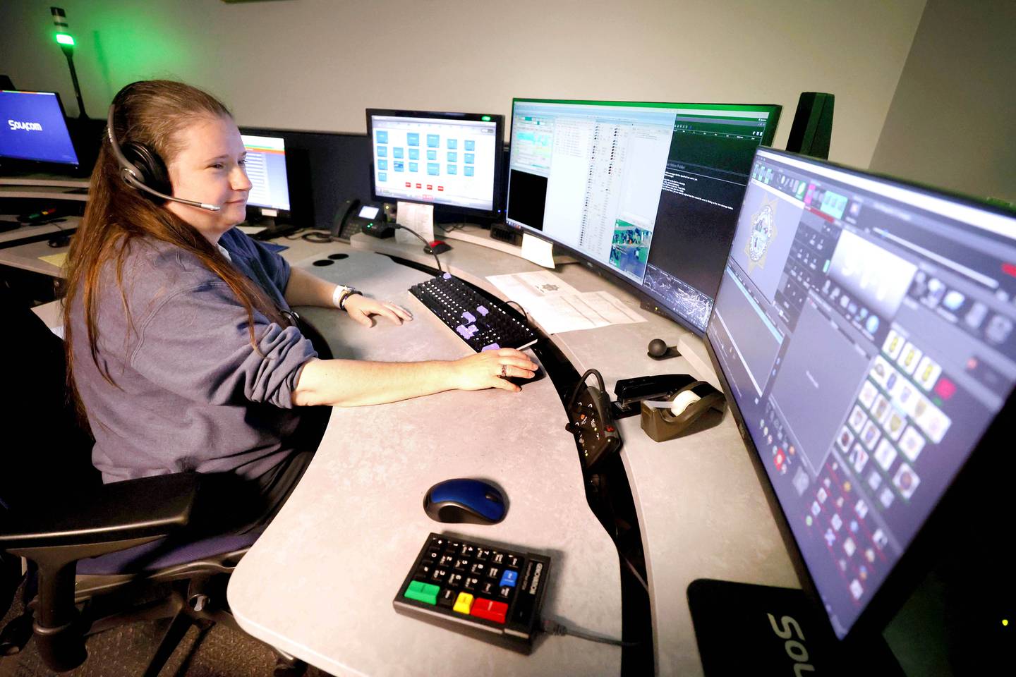 DeKalb County Sheriff’s Deputy Laura Flink takes calls at her dispatch station Monday, April 20, 2026, in the DeKalb County Sheriff's dispatch center in Sycamore.