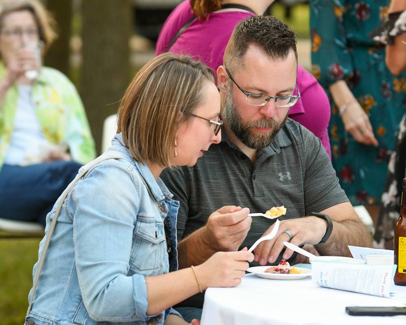 Anastasia Woyna and husband Sean Woyna from Esmond sample food and fill out their ballot during the 20th anniversary of 50 Men Who Cook, an annual fundraiser hosted by CASA DeKalb County at the Barsema Alumni and Visitors Center at Northern Illinois University in DeKalb on Saturday, Aug. 10, 2024.