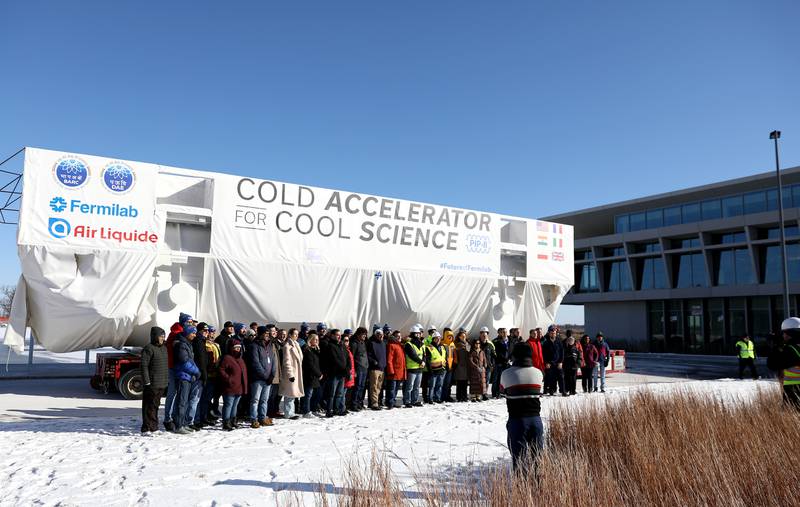 Fermilab employees pose for a photo in front of the 95-ton cold box on Wednesday, Jan. 15, 2025, following a two month journey from France to Batavia. The coldbox is a crucial piece of equipment for the lab’s new Proton Improvement Plan II (PIP-II) particle accelerator project.
