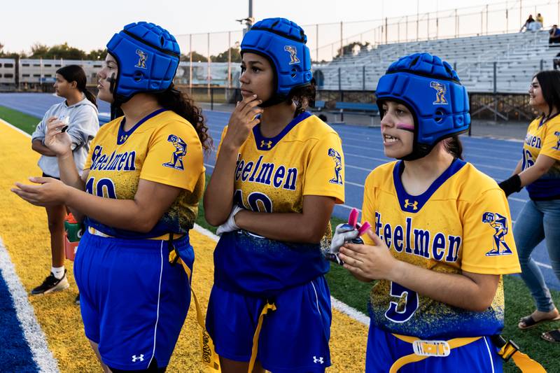 Joliet Central's Alexa Hook, Alivia Smith, and Amia Zavala watch the action from the sideline during a varsity flag football home game against Bloom on Sept. 11, 2025.