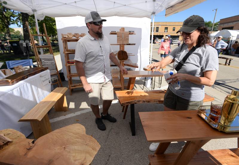 Artist David Blunt of Wisconsin and Roxana Hernandez of Berwyn talk about one of David's tables during the LaGrange Art Festival Saturday, Sept. 9, 2023.