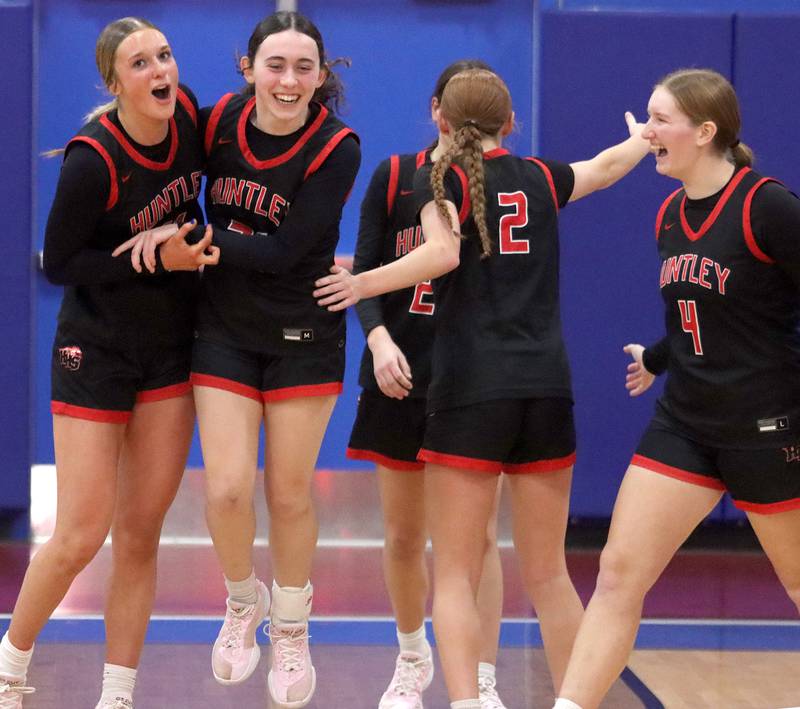 Huntley’s Red Raiders celebrate a win over Maine South in Komaromy Holiday Classic varsity girls basketball championship game action on Monday, Dec. 30, 2024, at Dundee-Crown High School in Carpentersville.