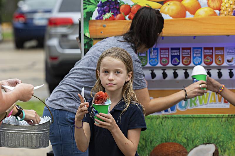 Dorien Deets, third grader at St. Mary’s School in Dixon, flavors up her shaved ice Friday, Sept. 22, 2023 outside of the school.
