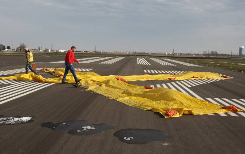 Fischer Excavating foreman Toby Landrus and superintendent Chad Swalve removed sandbags and a giant yellow "X" Thursday morning to open the new east-west runway at Illinois Valley Regional Airport, Peru. The Illinois Department of Transportation Division of Aeronautics inspected and opened the 4,000-foot runway, which gives pilots an alternative to the north-south runway when westerly winds are blowing.