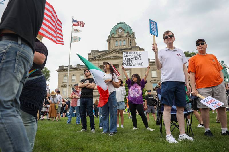 Protesters hold signs as approximately 500 people gathered at the Kankakee County Courthouse for a ‘No Kings’ rally in Kankakee on Saturday, June 14, 2025, to protest actions by President Donald Trump.
