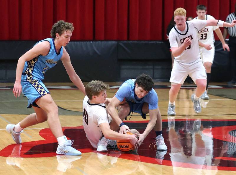 Indian Creek and Marquette players go after a loose ball Monday, Dec. 9, 2025, during their game at Indian Creek High School in Shabbona.