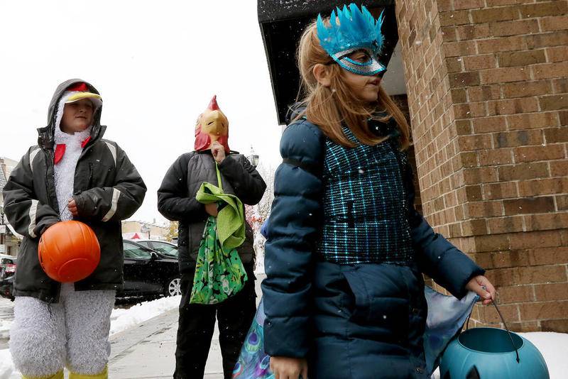 File photo: From left: Dressed as a chicken, Jack Rickard, 10, Gabe Rickard, 12, dressed as an eskimo chicken, and Beatrice Rickard, 8, dressed as a peacock, embark on a journey for free candy during trick or treating hours on a snowy Halloween, Thursday, Oct. 31, 2019 in downtown Crystal Lake.
