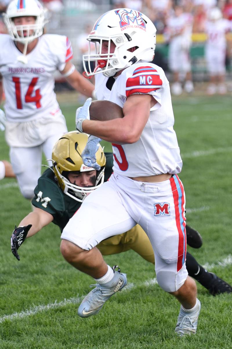 Marian Central's Mike Schmid, right, looks to run past a tackle attempt from Bishop McNamara's Zane Gulley during a game at Bishop McNamara Saturday, Oct. 4, 2025.