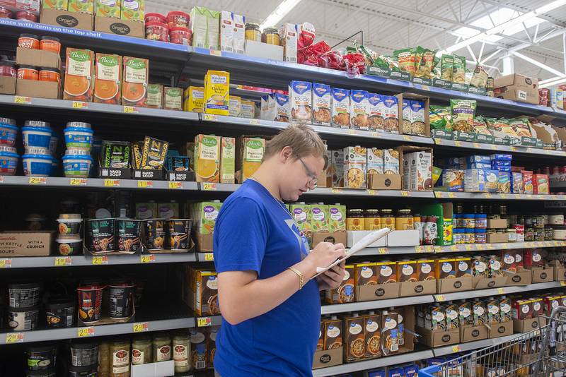 East Coloma-Nelson Life Skills class member Gage Hoefte adds up groceries Thursday, May 19, 2022 while on a shopping trip with his class. Special ed teacher Richard Melcher leads the class on weekly trips to Walmart to shop, add and scan items for a recipe the group picks out. The weekly trips help the students with budgeting and item selection.