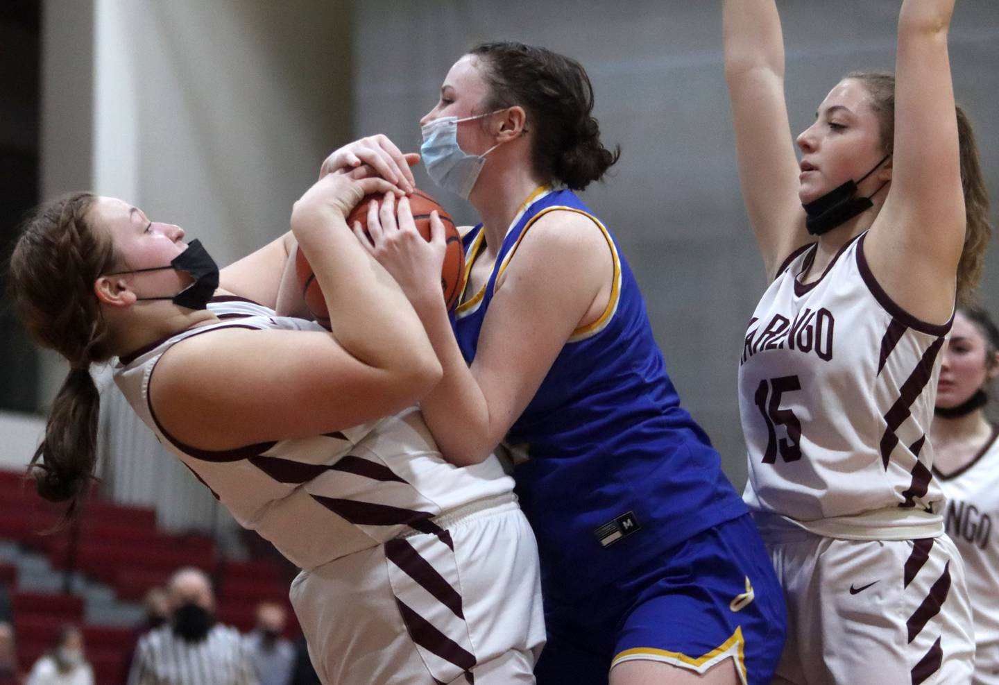 Marengo’s Morgan Coffman, left, tussles with Johnsburg’s Bella Saxelby for the ball as Marengo’s Gianna Almeida, right, keeps an eye on the action during girls varsity basketball action in Marengo Thursday night.