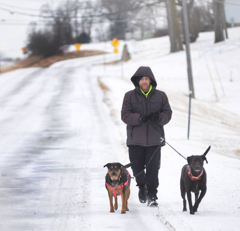 Ray Green and his dogs, Bob and Marley, didn't let a little snow stop them from taking their daily walk on North Frontage Road between Dixon and Sterling on Wednesday, Feb. 12, 2025.