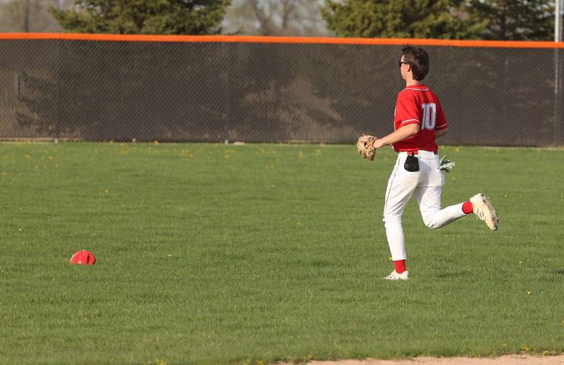 Naperville Central's Cooper Page has to chase down his hat on a windy day Monday, April 28, 2025, during their game at DeKalb High School.