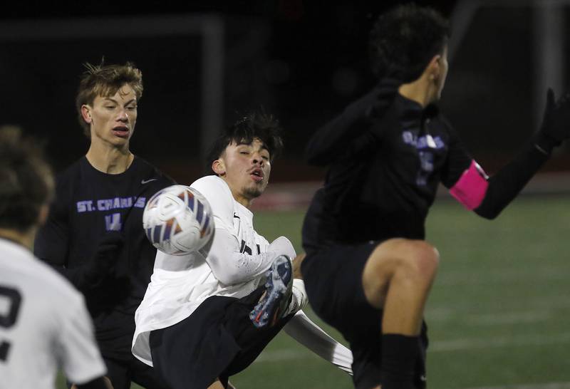 McHenry's Aldair Anglada tries to control the ball between St. Charles North's Ashton Goetteli (left) and Wicho DelaPaz (right) during an IHSA Class 3A Huntley Regional boys soccer semifinal match on Tuesday, Oct. 21, 2025, at Huntley High School.