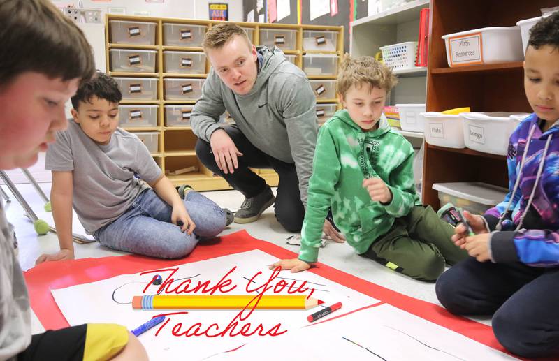 Jacob Winters, fourth grade teacher at South Prairie Elementary School, works with students during a robotics lesson Wednesday, April 6, 2023, at the school in Sycamore.