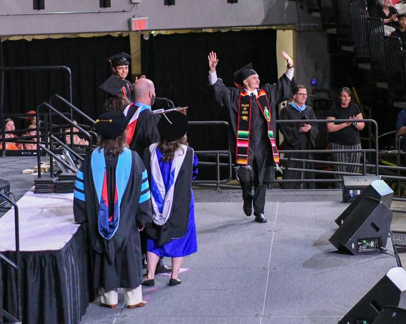 DeKalb High School senior Class President Michael Biundo waves to the crowd after his name was called to receive his diploma on Saturday, May 24, 2025, during the Class of 2025 Commencement ceremony held at the NIU Convocation Center in DeKalb.