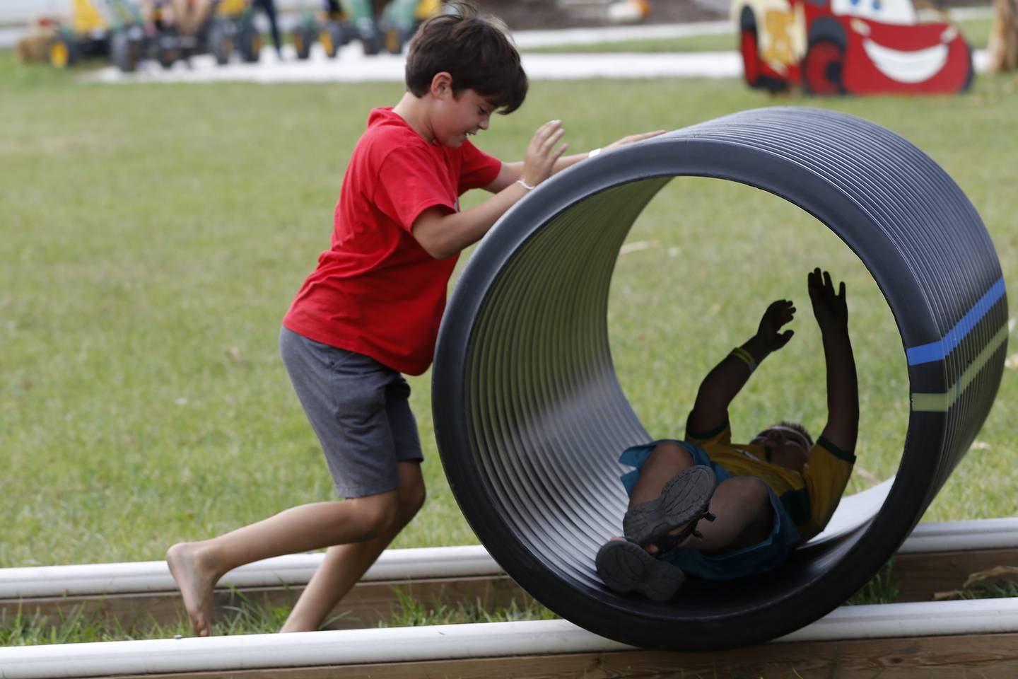 Noah Negrete, 9, of St. Charles, left, pushes Dmitri Intzekiotis, 2, of Huntley, in a tube on tracks during the Fall on the Farm event at Tom's Market on Saturday, Oct. 2, 2021 in Huntley.  The month-long event began on Friday and will conclude Oct. 31.