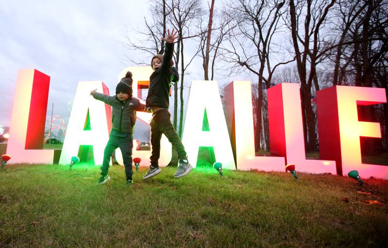 Harlen and Greyson Hodges of Peru, jump with excitement in front of the "La Salle" letters during the second annual Run, Run Rudolph 5K on Sunday, Nov. 10, 2024 at Rotary Park in La Salle.