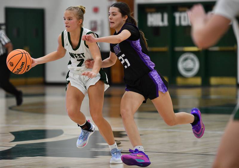 Glenbard West’s Katie Meehan (left) races with Downers Grove North’s Caitlin Sandridge during a game on December 4, 2025 at Glenbard West High School in Glen Ellyn.