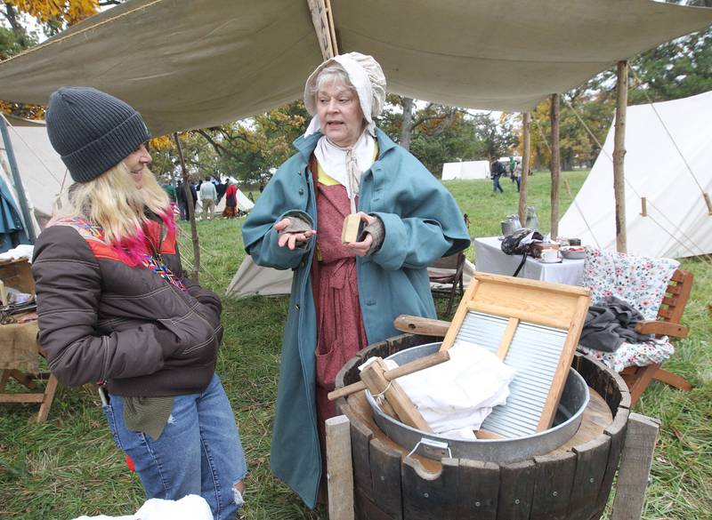 Karie OConnor, of New Lenox talks with Eileen Partak, of Manhattan, as she portrays a laundress, about the lye soap used to clean soldiers clothes during Hainesville’s Civil War Encampment & Battle at the Northbrook Sports Club on October 21st in Hainesville. 
Photo by Candace H. Johnson for Shaw Local News Network