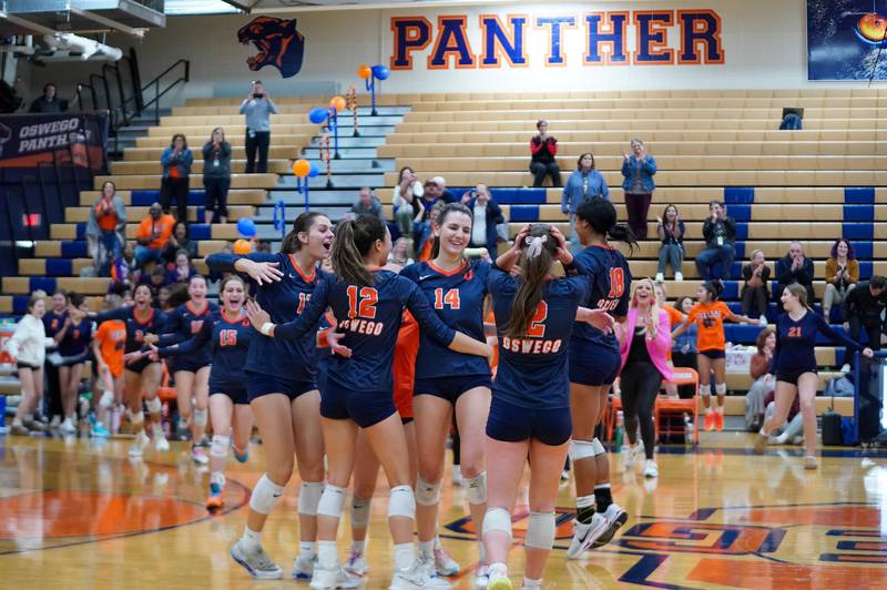 Oswego players celebrate after defeating Joliet West during a volleyball match at Oswego High School on Thursday, October 24, 2024.