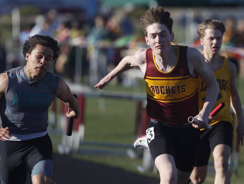Richmond-Burton’s Sean Rockwell leans into the finish line in front of Woodstock North’s Mark Duenas at the finish of the 4X100 relay Thursday, April 21, 2022, during the McHenry County Track and Field Meet at Richmond-Burton High School.