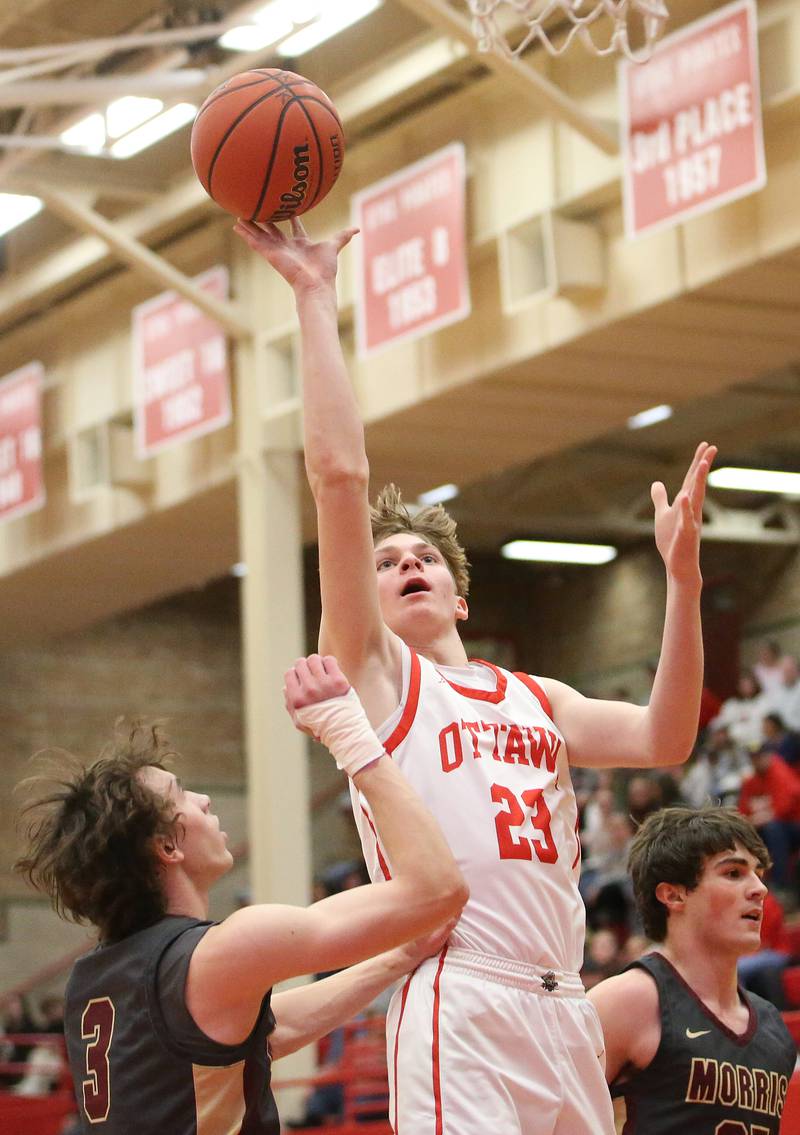 Ottawa's Owen Sanders eyes the hoop while splitting a pair of Morris defenders Caston Norris and Blane Beshoar on Wednesday, Jan. 3, 2024 at Kingman Gym.