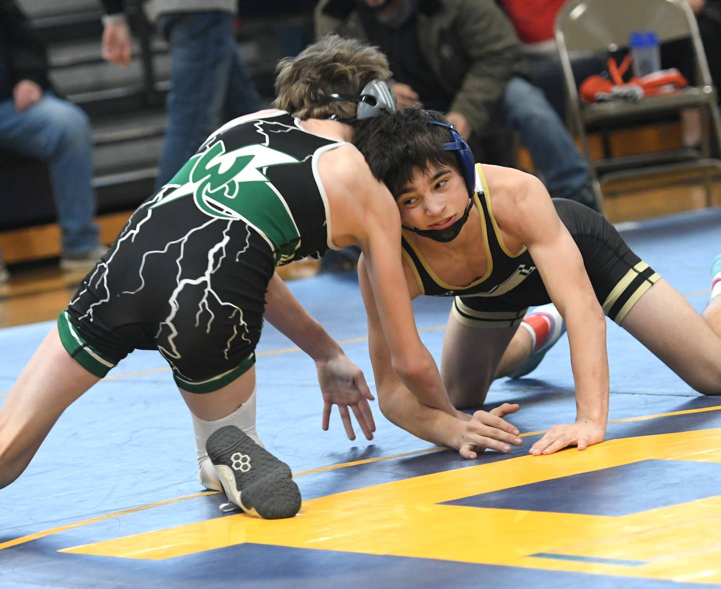 Polo's Josiah Perez (right) battles West Carroll's Connor Knop in the 106-pound championship bout at the Polo Wrestling Invitational on Saturday.