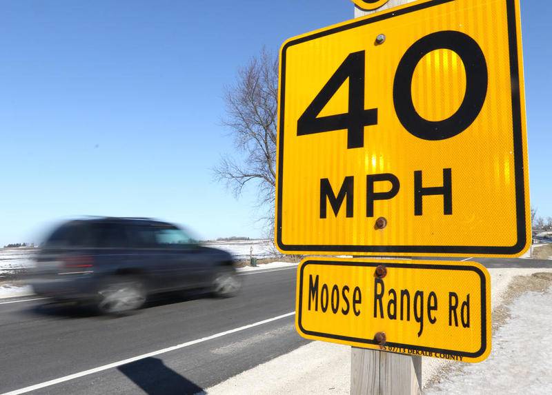 An SUV races by a sign indicating the suggested speed limit on the curve where Plank Road intersects with Moose Range Road Friday in Sycamore. The 55 mph speed limit on Plank near the intersection is being reduced to 45 mph. While the current posted advisory speed limit through that curve is 40 mph.