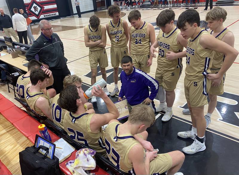 Serena boys basketball coach Dain Twait (center) talks things over with his Huskers before the start of the fourth quarter against Woodland on Monday, Jan. 8, 2024, at the Warrior Dome in rural Streator.