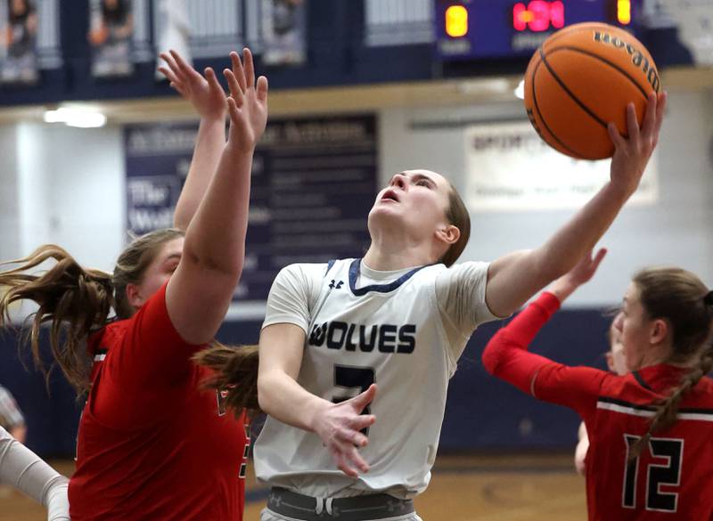 Oswego East's Maggie Lewandowski tries to score over Yorkville's Madison Spychalski during their game Tuesday, Feb. 11, 2025, at Oswego East High School.