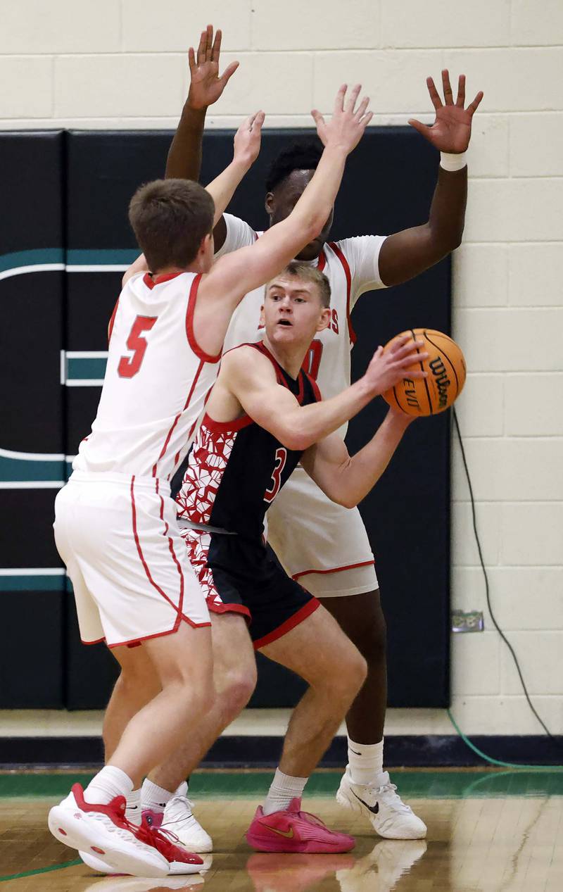 Glenbard East's Danny Snyder (3) is surrounded by Palatine's Robbie Wilcox (5) and Tony Balanganayi (50) during the 51st Jack Tosh Holiday Classic basketball tournament Monday, Dec. 29, 2025 at York High School in Elmhurst.