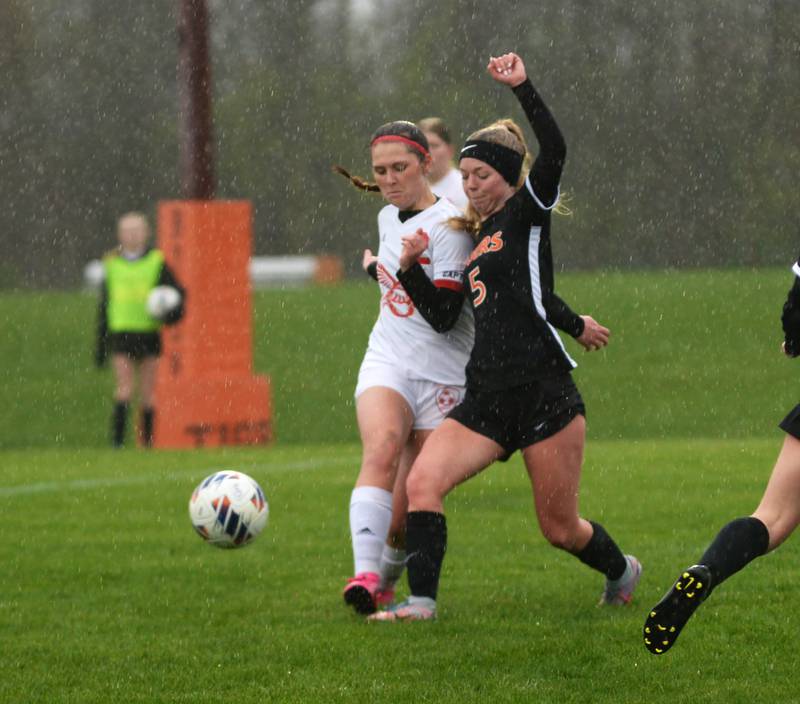 Oregon's Anna Stender (2) and Byron's Claire Hinnkel (5) battle for the ball as rain falls on Thursday, April 18, 2024 at Byron High School.