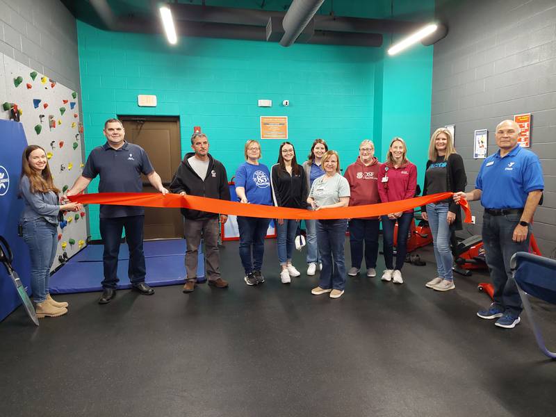 Participating in a ceremonial ribbon cutting for the Streator YMCA's new action arcade equipment are donors from International Brotherhood of Electrical Workers Local 601, OSF HealthCare, Vactor Manufacturing and SOCU on Saturday, April 20, 2024.