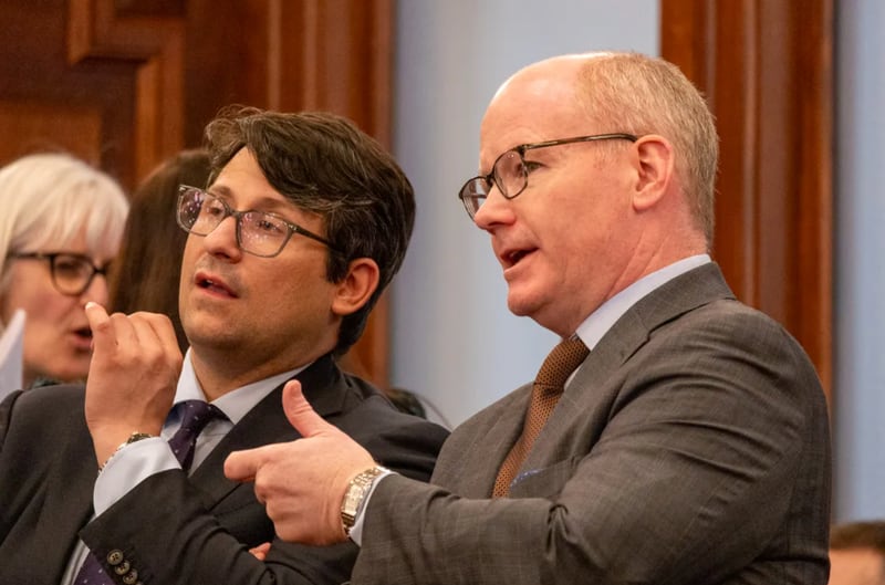 Senate President Don Harmon, D-Oak Park, right speaks with a Senate staffer a few hours before debating a bill to reform the Prisoner Review Board.