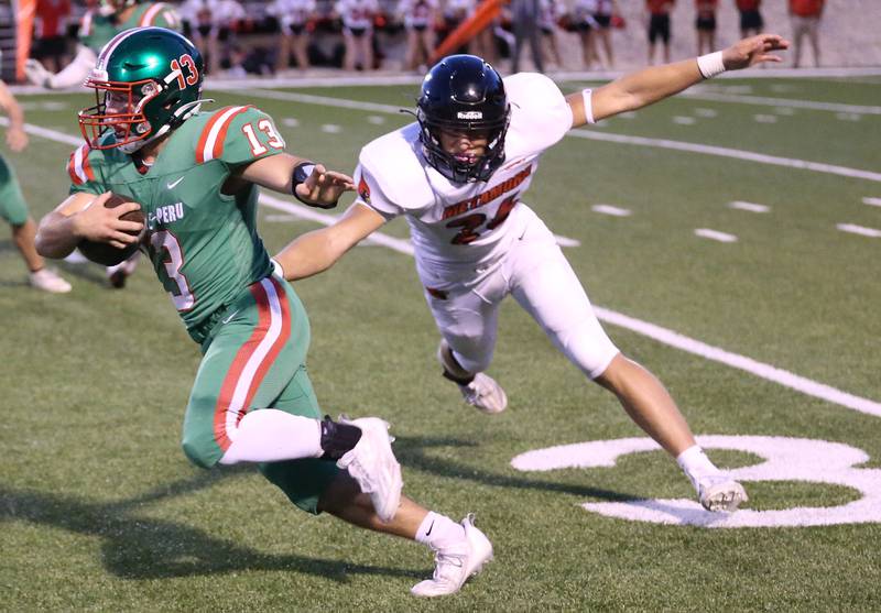 L-P's Brady Romagnoli runs past Metamora's Cam Nickel on Friday, Sept. 1, 2023 at Howard Fellows Stadium.