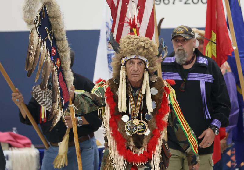 Wamlee Loux of the Sioux and Vietnam Navy Seal veteran, holds an Eagle Feather Staff while leading the Grand Entry for the Starved Rock Pow Wow on Saturday, Nov. 1, 2025 at the Utica Village Hall.