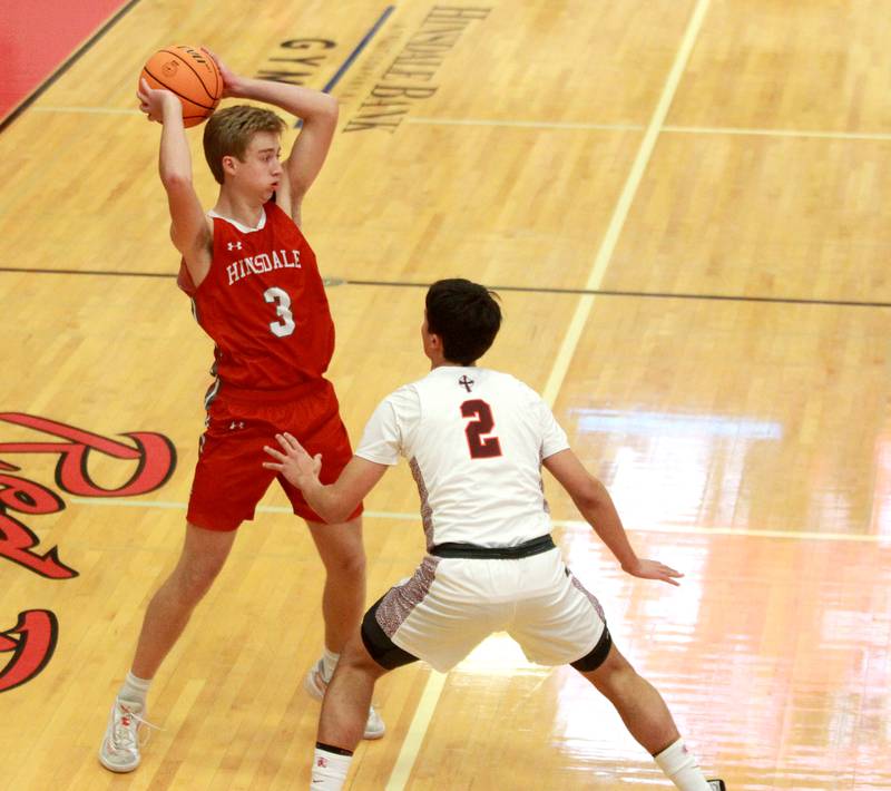 Hinsdale Central’s Dillon Dell looks to pass the ball over Brother Rice’s Jack Weigus in the Hinsdale Holiday Classic championship game on Monday, Dec. 30, 2024 in Hinsdale.