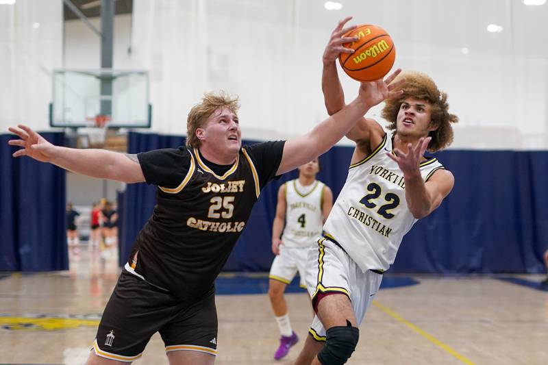 Joliet Catholic's Michael Lynch (25) and Yorkville Christian's Noah Aguado (22) fight for a long rebound during a basketball game at Yorkville Christian High School on Monday, January 13, 2025.