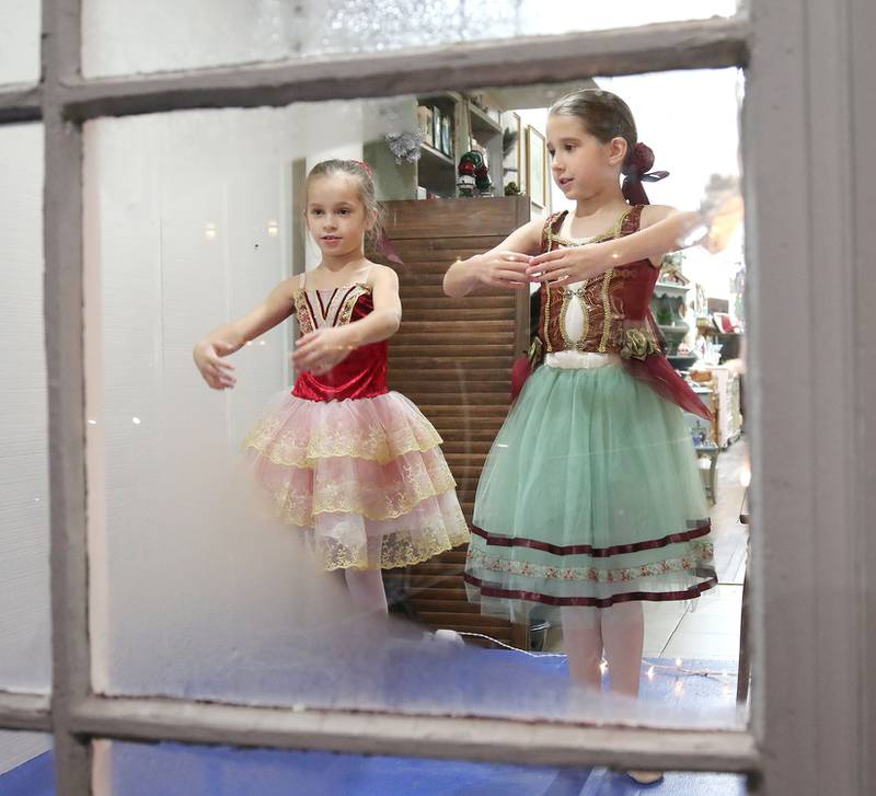Adelyn Cordes, (left) 7, and Everly Johnson, 8, both from DeKalb dance in the window of Blu Door Decor Friday, Nov. 12, 2021, during the Second Fridays event, themed “Tinsel and Traditions.” The night was hosted by downtown DeKalb merchants and Dimensions Youth Ballet.