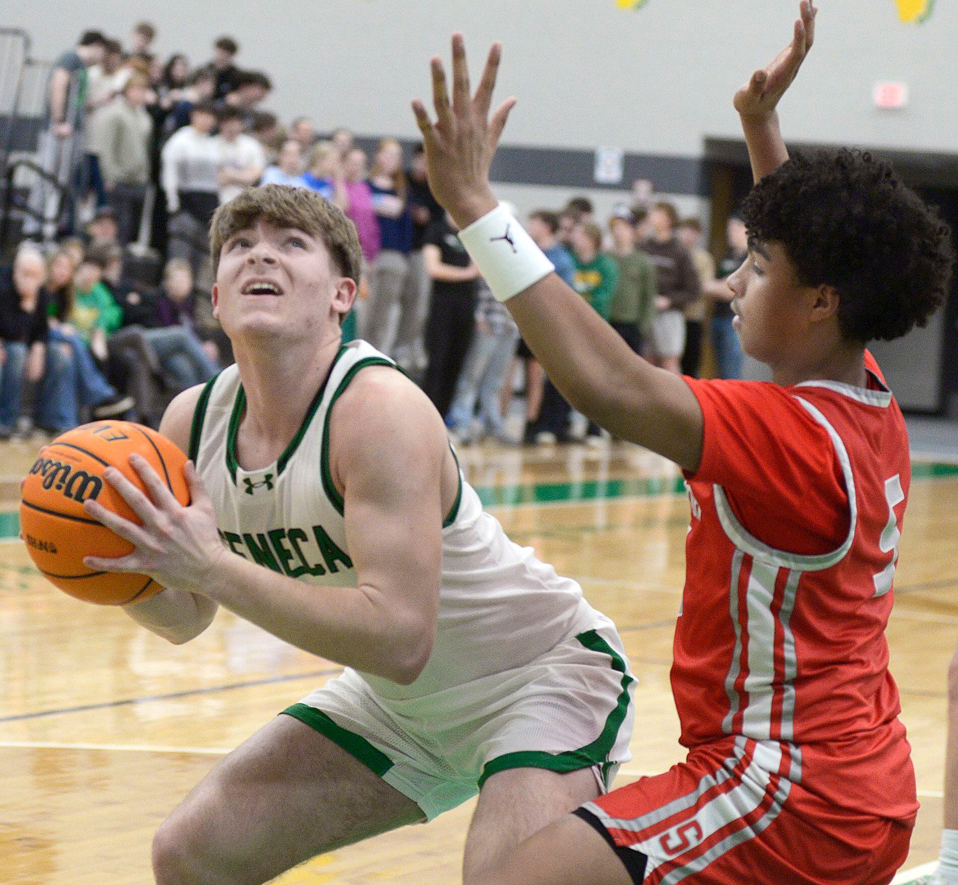 Seneca’s Cam Shriey eyes the basket as Seneca’s Lavontae Horton sets to block in the second period Tuesday at Seneca.