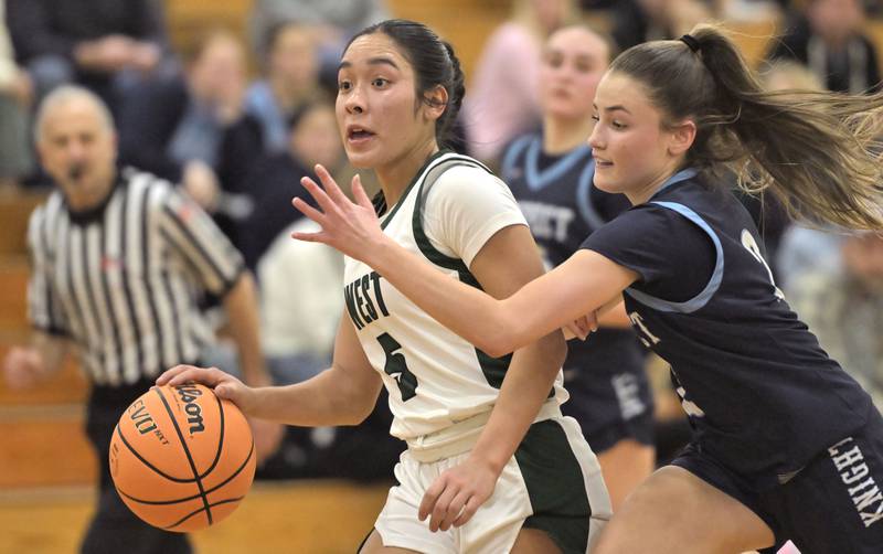 Glenbard West’s Lauren Escalante tries to stay ahead of Prospect’s Neve Pomis in a girls basketball game in Glen Ellyn on Thursday, Jan. 9, 2025.