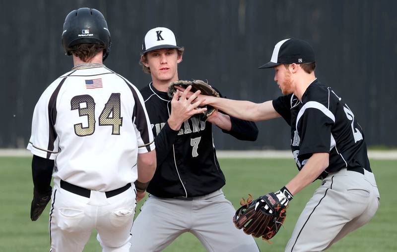 Kaneland's Tom Thill hands the ball to teammate Matthew Brunscheen to force out Sycamore's Davis Collie at second during their game Monday, April 22, 2024, at the Sycamore Community Sports Complex.